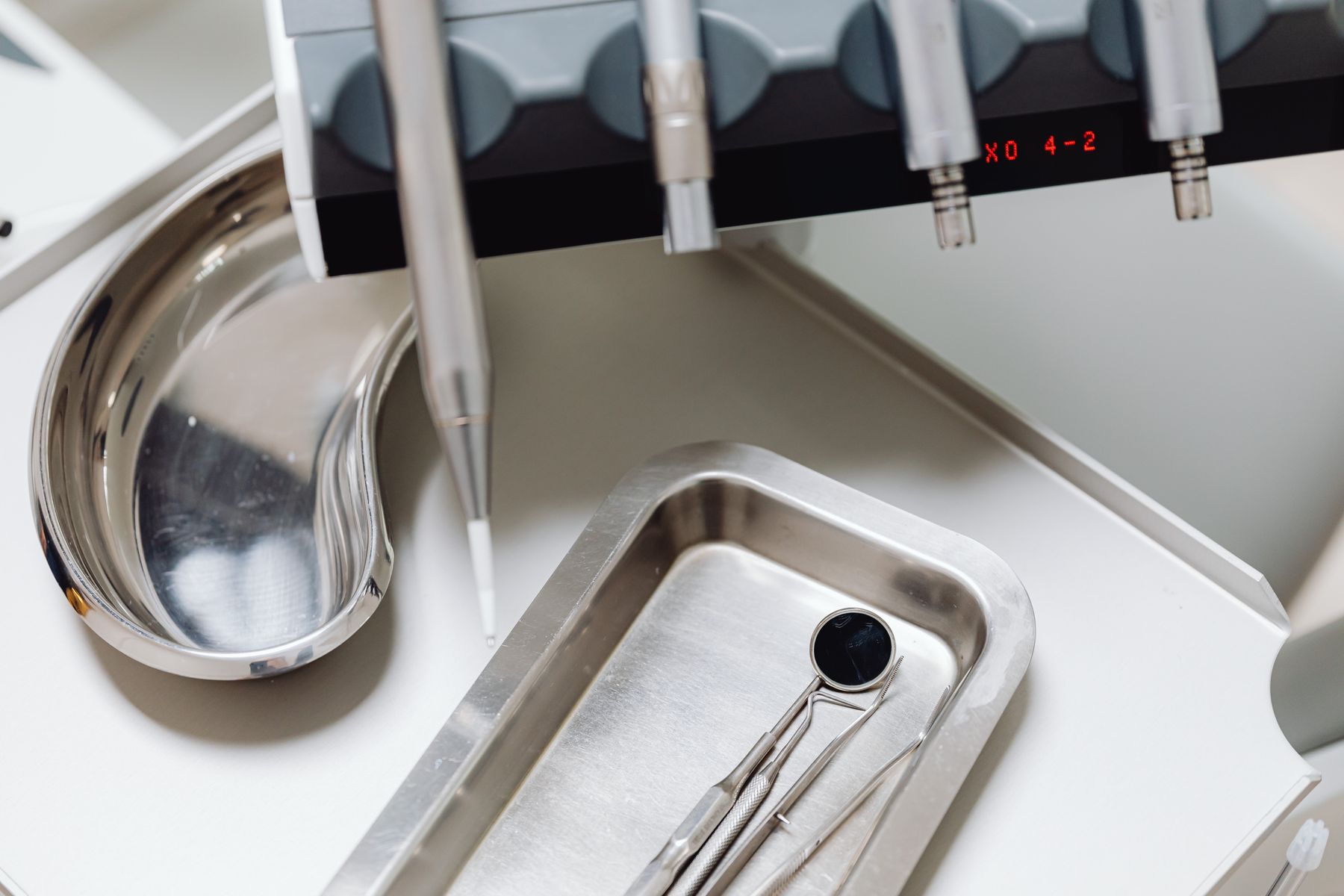 Sterile dental examination instruments arranged on a metal tray in a clinic